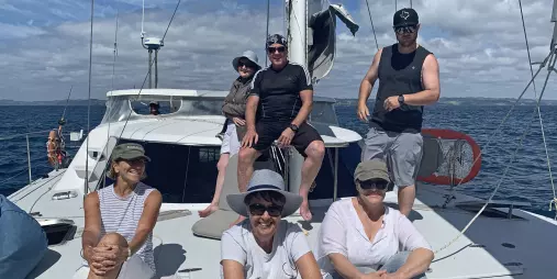 Yacht sailing across calm blue waters under clear skies