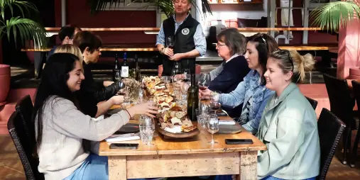 Guests enjoying a guided wine tasting with shared platters at Stonyridge Vineyard on Waiheke Island, New Zealand