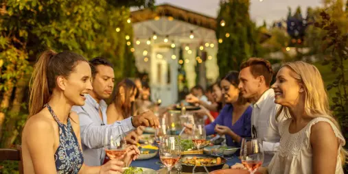 Friends enjoying wine and dinner together during a Waiheke Island wine tour at a vineyard restaurant