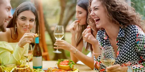 Friends enjoying food and wine pairing during Waiheke Sip Happens wine and beer tour