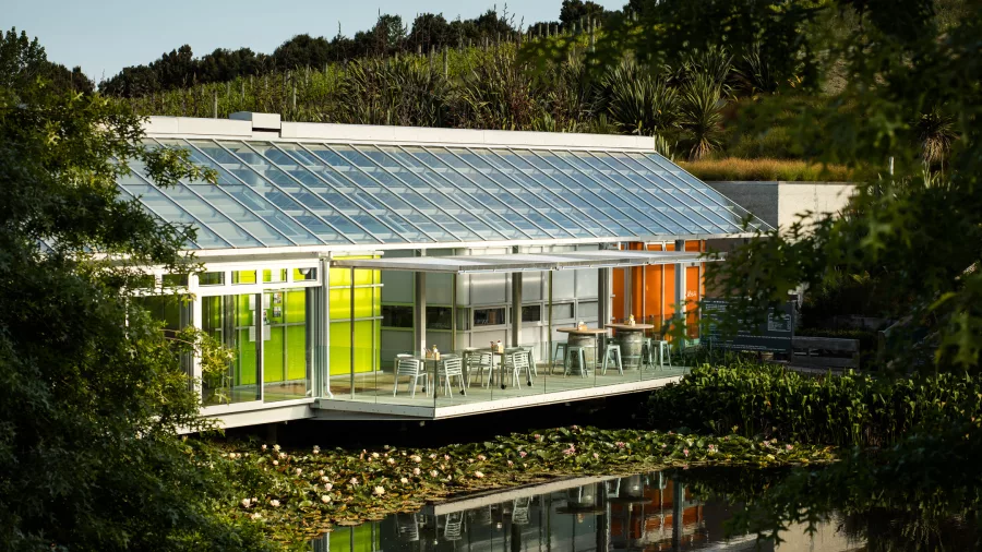 Brick Bay Glass House restaurant with sunlit glass walls overlooking the lake and gardens in Snells Beach