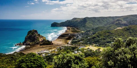 Piha Beach with black sand, powerful surf, and Lion Rock on New Zealand’s wild west coast