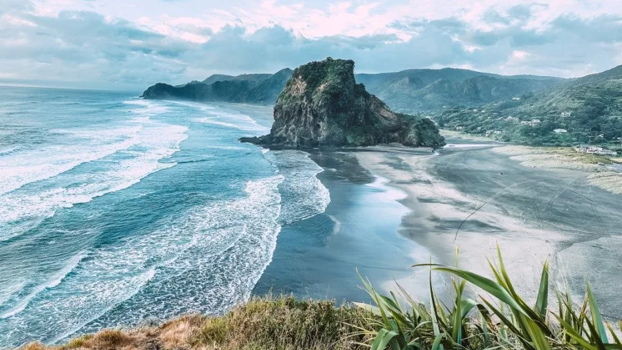 Aerial view of Piha Beach and Lion Rock with rolling surf on Auckland’s west coast