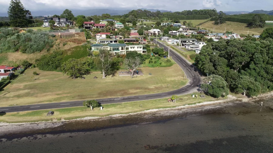 Aerial view of homes and grassy reserve along the shoreline at Ongare Point