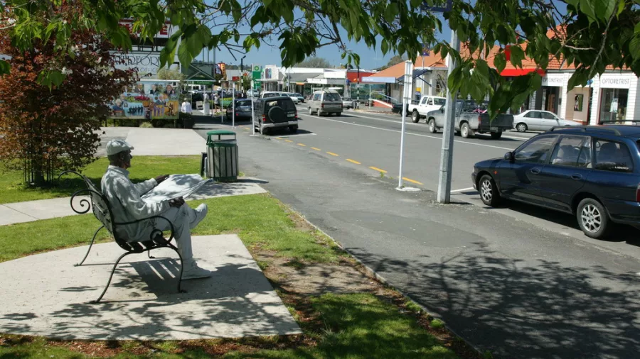Statue of a man reading a newspaper near Katikati’s main street shops