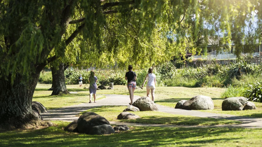 People walking along a tree-lined path in Uretara Stream Reserve, Katikati, New Zealand