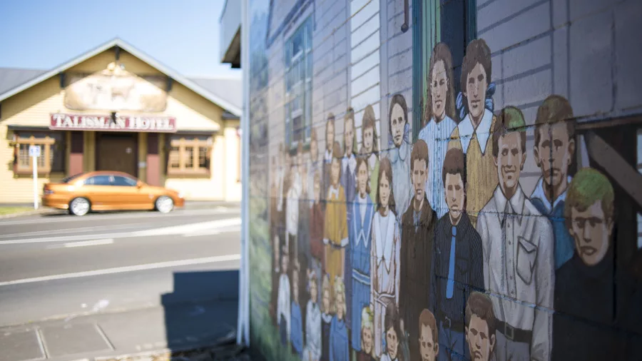 Colourful mural of people on a wall near the Talisman Hotel in Katikati, New Zealand
