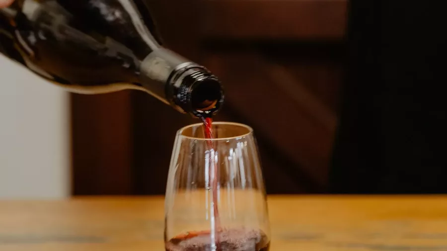 Pouring red wine into a glass at Leveret Mills Reef Cellar in Katikati, New Zealand