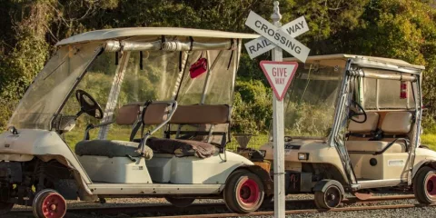 Self-drive rail carts crossing a railway intersection on the Awakeri Rail Adventures line