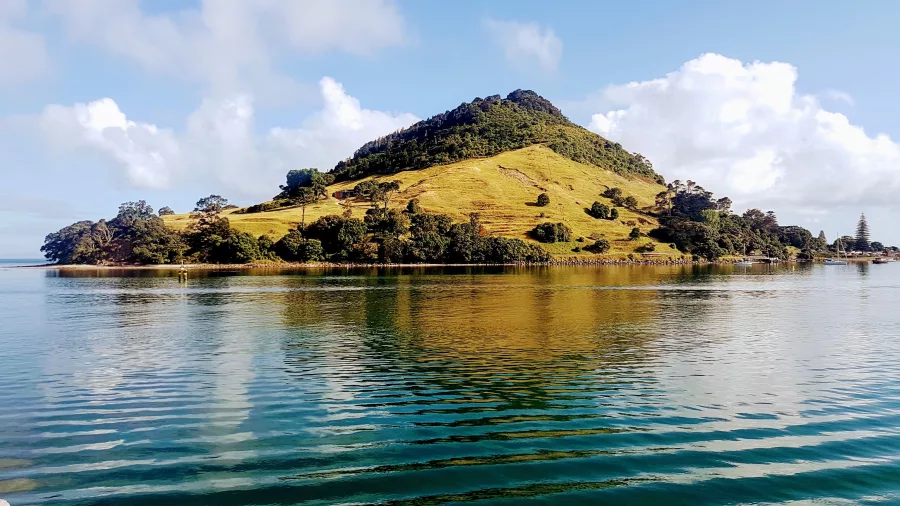 View of Mauao (Mount Maunganui) from the water with reflections in the harbour