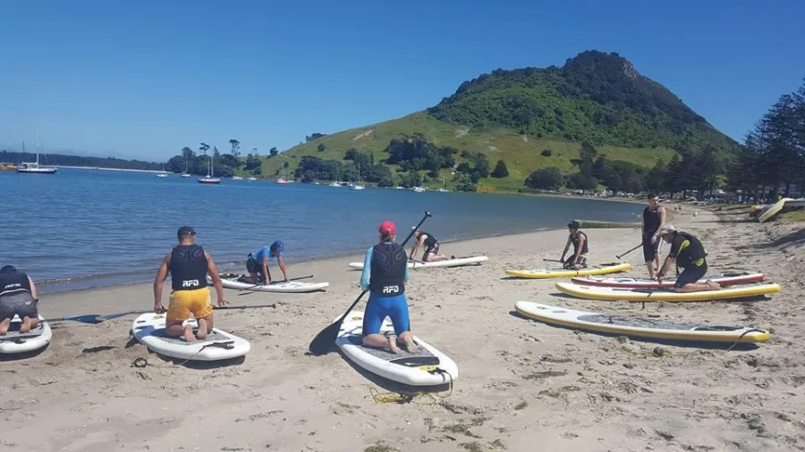 Beginner SUP lesson on the beach with Mauao in the background