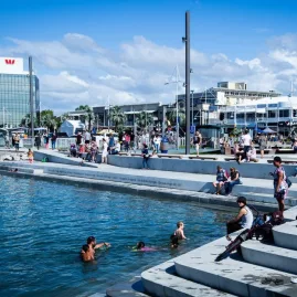 Locals and visitors enjoying the Tauranga waterfront with modern buildings in the background