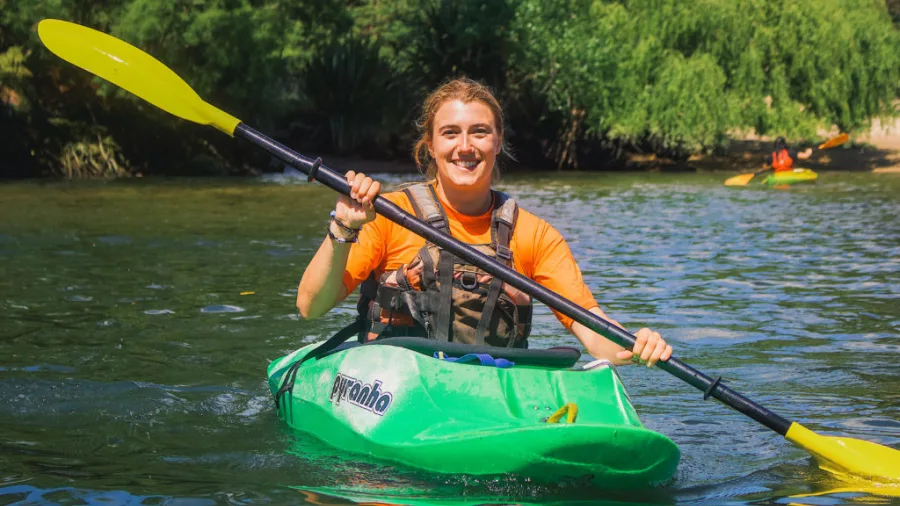 Happy woman kayaking in green kayak at Waimarino