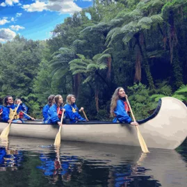 Visitors paddling through McLaren Falls Park in a Big Kanu surrounded by native forest