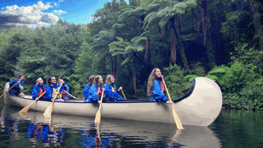 Visitors paddling through McLaren Falls Park in a Big Kanu surrounded by native forest