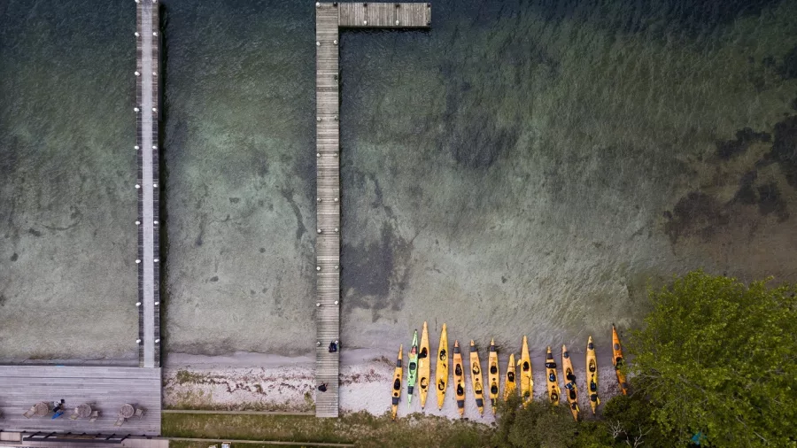 Bird’s-eye view of kayaks lined up beside a jetty on the clear waters of Lake Rotoiti