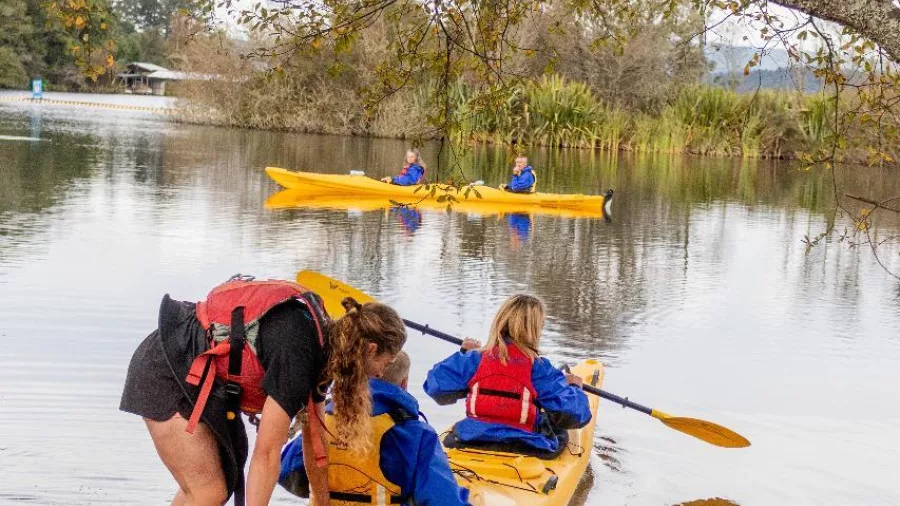 Couple launching a tandem kayak for a scenic Lake Rotoiti tour in Rotorua