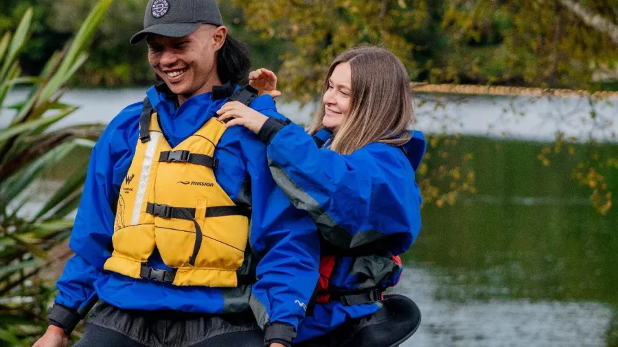 Couple smiling and preparing for a kayak tour on Lake Rotoiti in Rotorua, New Zealand