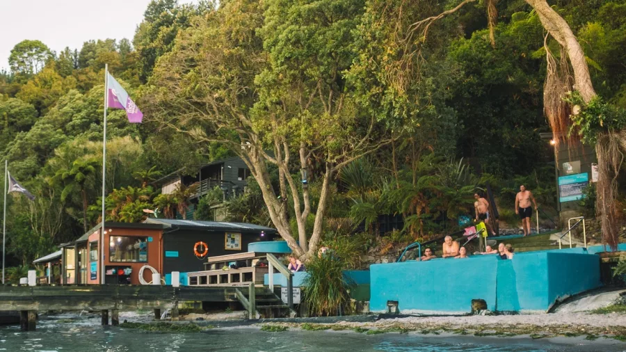 View of Manupirua Hot Pools and bathers from the lake at Lake Rotoiti, Rotorua
