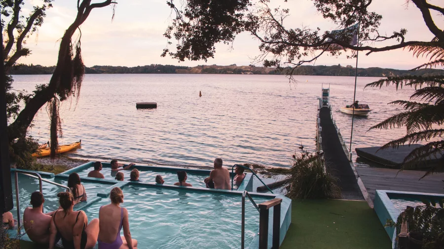 People relaxing in the Manupirua Hot Pools during the day on Lake Rotoiti, Rotorua