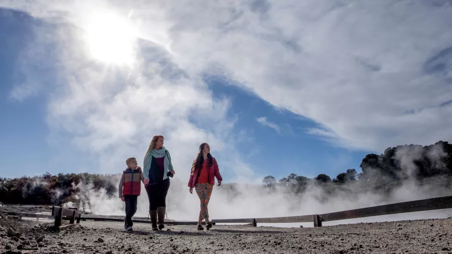 Family exploring the geothermal walk at Hell’s Gate on a sunny Rotorua day.