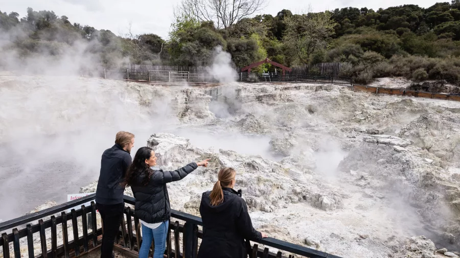 Visitors looking over an active geothermal crater from a viewing platform at Hell’s Gate Rotorua.
