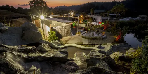 Scenic view of Hell’s Gate Rotorua at sunset, showing steaming pools and natural rock features.