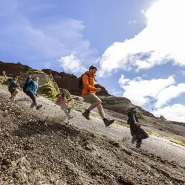 Group running down a scree slope inside the Mount Tarawera crater on a guided tour.