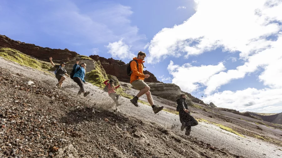Group running down a scree slope inside the Mount Tarawera crater on a guided tour.