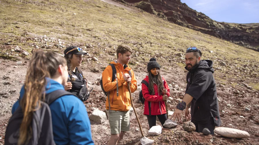 Guide explaining volcanic features to a small group on Mount Tarawera.