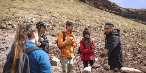 Guide explaining volcanic features to a small group on Mount Tarawera.