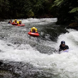 Sledgers navigating intense white-water rapids on the Kaituna River.