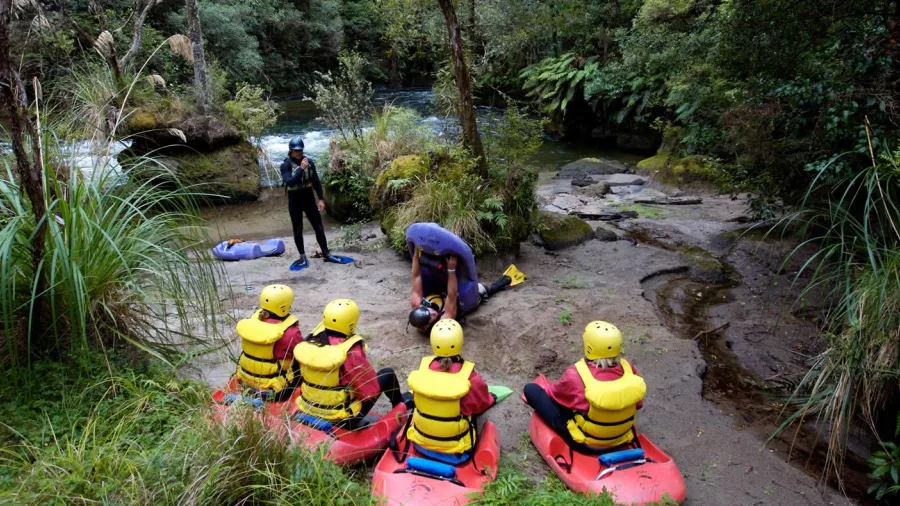 Group of adventurers receiving a safety briefing before sledging the Kaituna River.