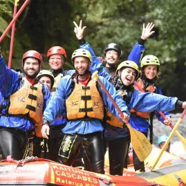 Group of smiling rafters in wet gear celebrating after their Kaituna River adventure.