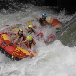 Rafting crew powering through intense white-water rapids on the Kaituna River in Rotorua.