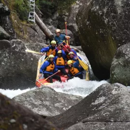 A raft navigating narrow, boulder-strewn rapids on the Wairoa River