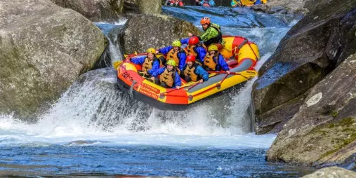 Raft mid-air on a steep Grade 5 waterfall on the Wairoa River near Rotorua.