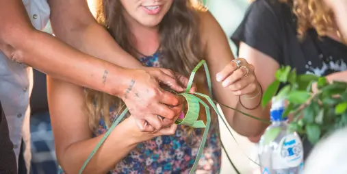 Guest learning traditional harakeke weaving during a Māori cultural experience at Kohutapu Lodge, Lake Aniwhenua