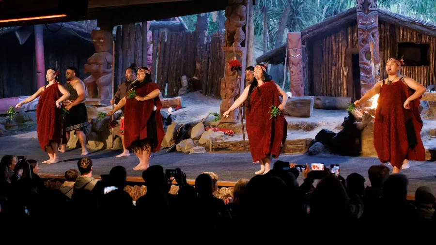 Māori performers dancing on stage in traditional dress at Mitai Māori Village, Rotorua.