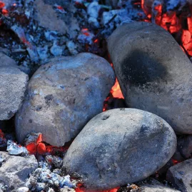 Glowing hot stones used in a traditional Māori hāngī at Mitai Village in Rotorua.