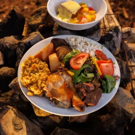 Traditional Māori hāngī meal served on hot rocks at Mitai Māori Village in Rotorua.