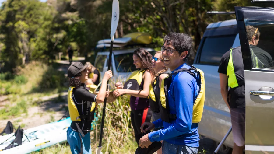 Group preparing kayaks and paddles before launching onto Lake Rotomahana, Rotorua.