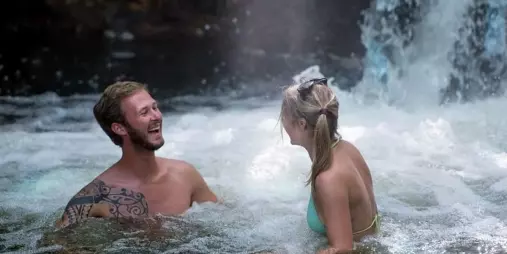 Couple relaxing and laughing in a natural hot spring near Rotorua