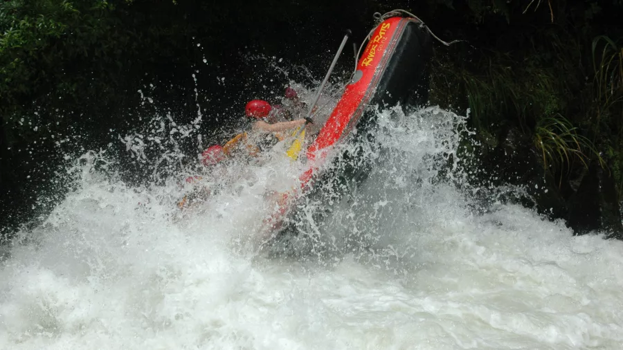 A raft flipping dramatically in powerful whitewater on the Upper Rangitāiki River.
