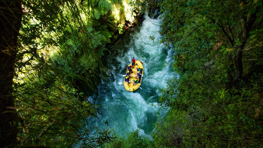 Raft travelling down a narrow gorge of the Kaituna River surrounded by native forest
