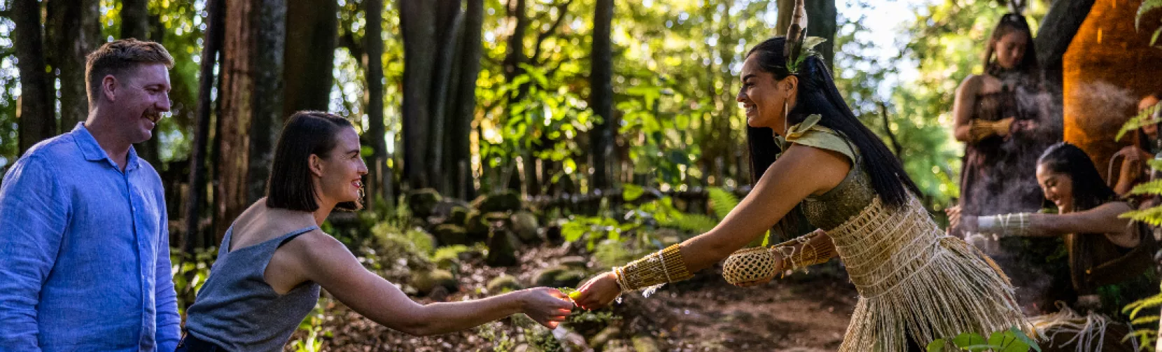 Māori woman in traditional dress welcoming guests in a forest at Te Pā Tū Rotorua