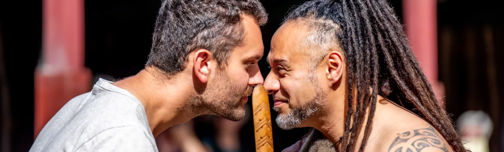 A guest and Māori host sharing a hongi greeting during a Te Pā Tū cultural welcome