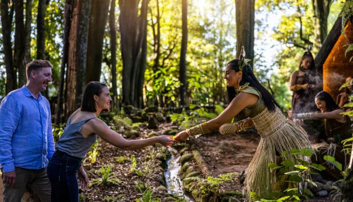 Māori woman in traditional dress welcoming guests in a forest at Te Pā Tū Rotorua