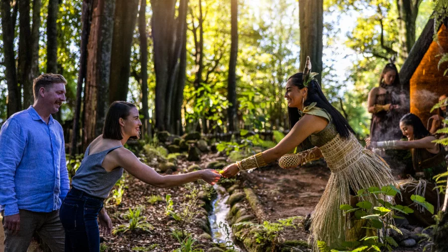 Māori woman in traditional dress welcoming guests in a forest at Te Pā Tū Rotorua