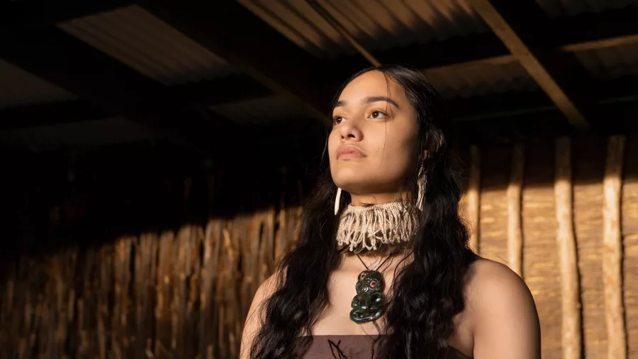 Portrait of a young Māori woman wearing a hei tiki at Te Pā Tū cultural event